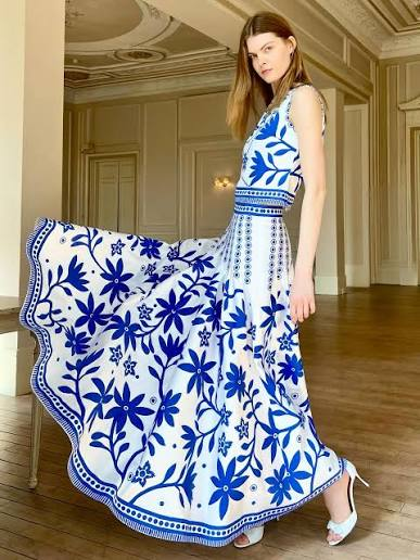 A model in a flowing white and blue floral evening dress