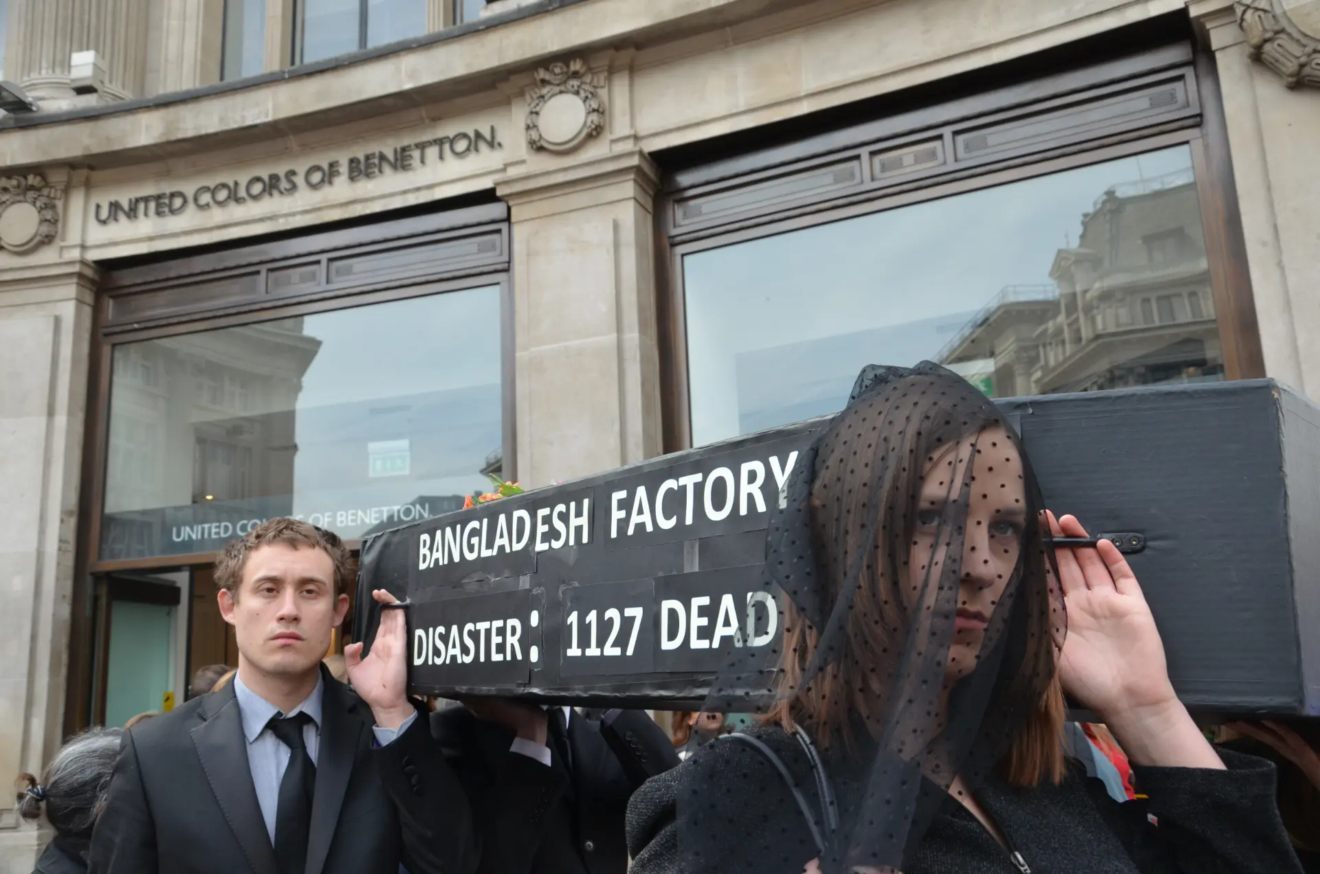 Protesters outside a Benetton store carry a coffin reading Bangladesh Factory Disaster: 1127 Dead