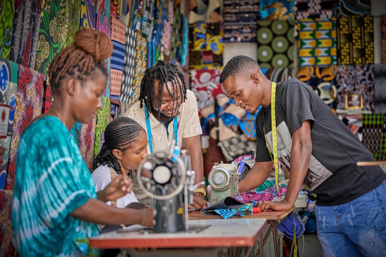 Tailoring instruction at a fabric market outside the camp.
