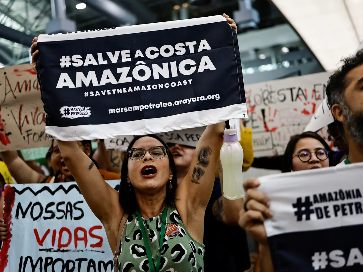 Protesters hold a banner reading '#SALVE A COSTA AMAZÔNICA' calling for Amazon rainforest protection