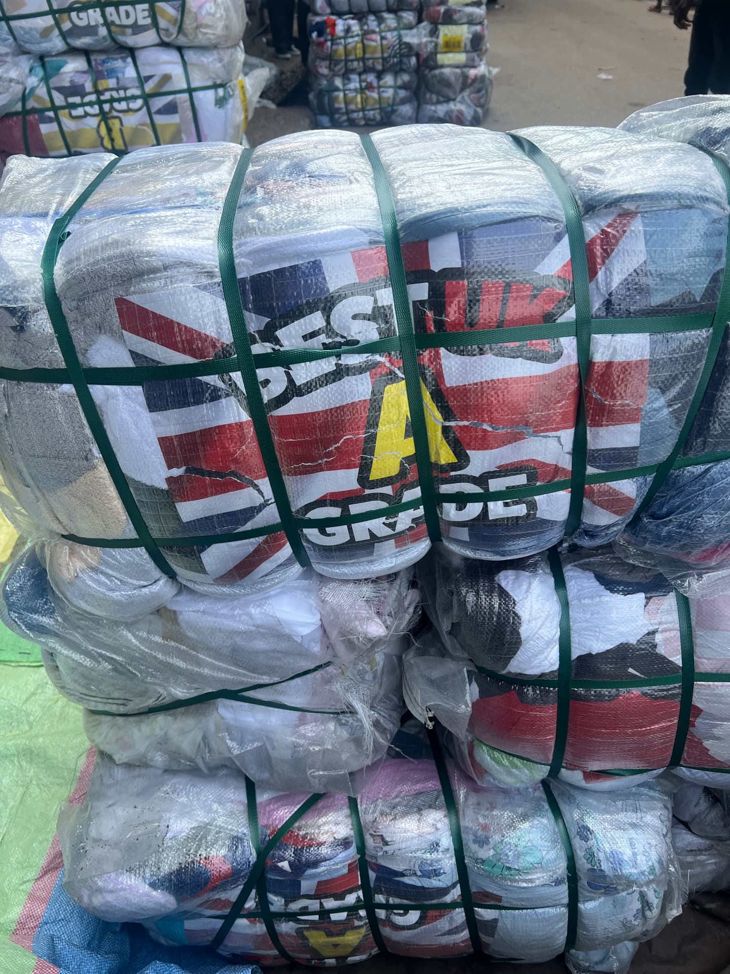 A bale of second-hand clothing labelled 'Best UK A Grade' stacked at Kantamanto Market, Accra.