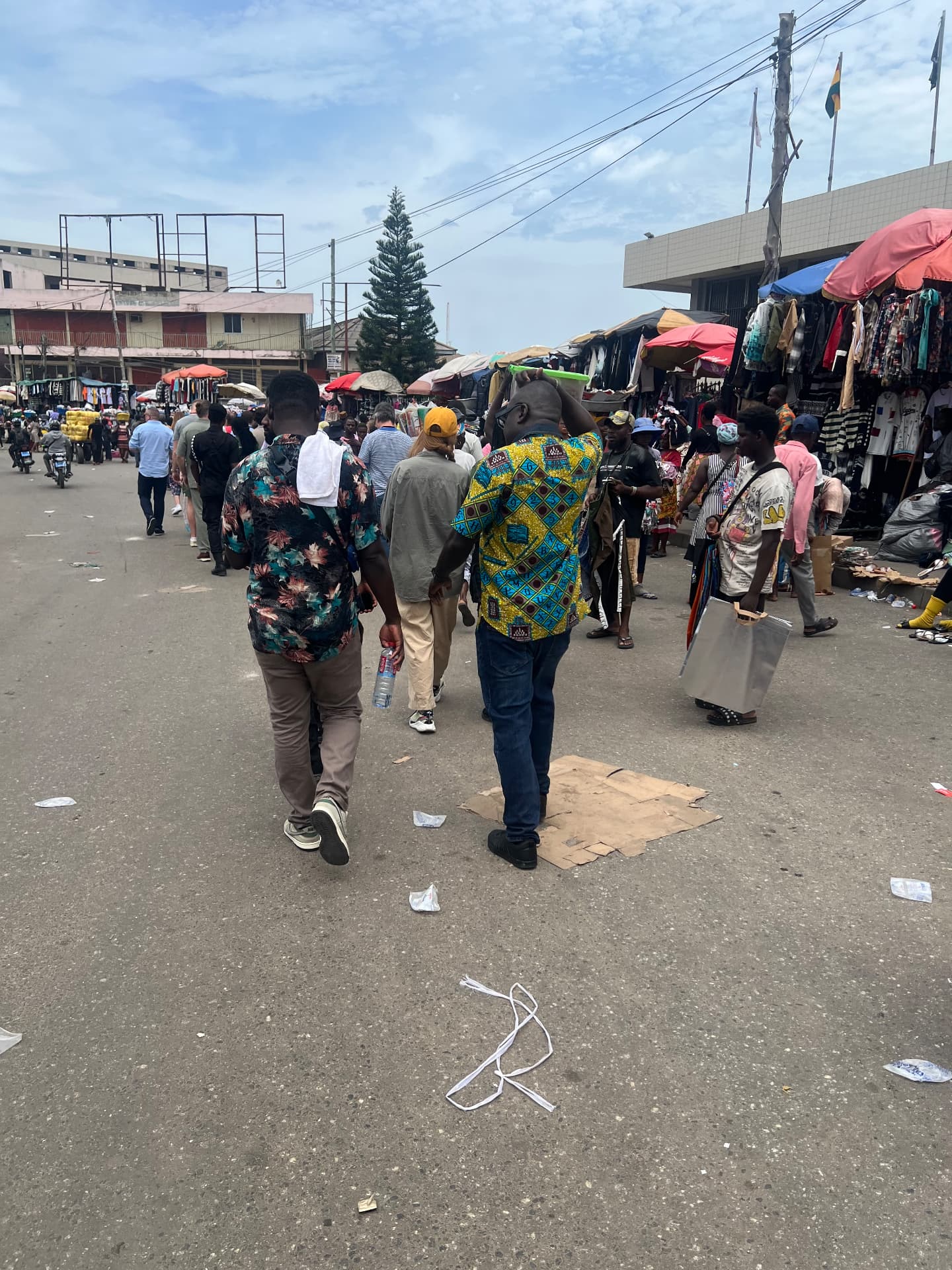 A wide view of the streets around Kantamanto Market with traders, porters and stalls.