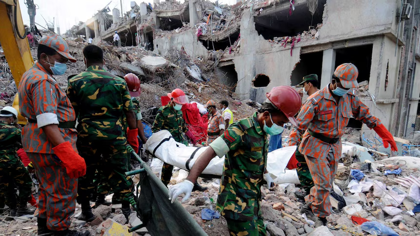 Rescue workers carry a victim on a stretcher through the rubble of the collapsed Rana Plaza building in Dhaka, April 2013
