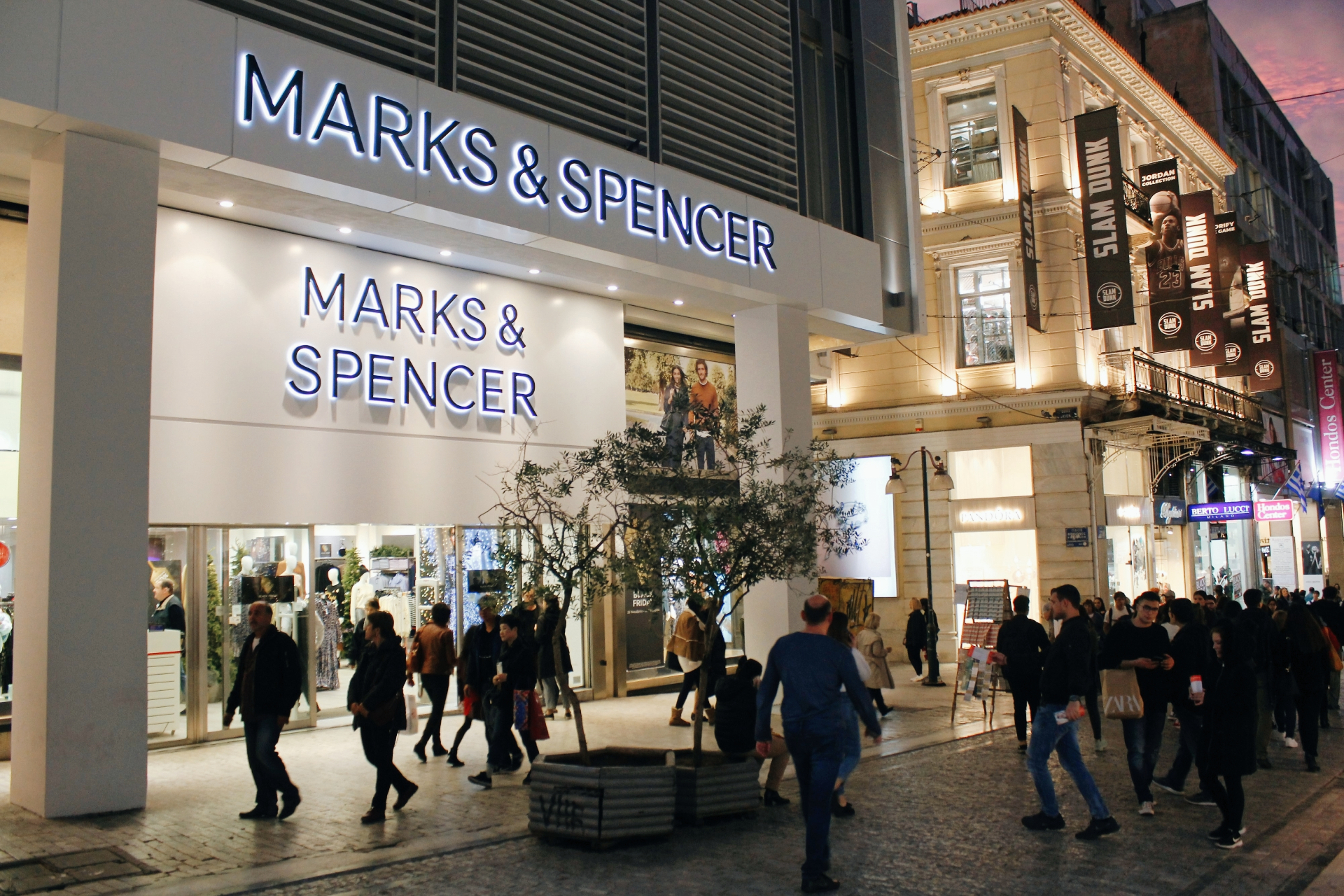 Marks & Spencer storefront on a busy high street at dusk